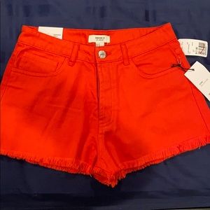 Red denim shorts with fray hem